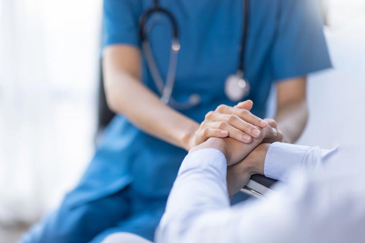 Läkare håller hand med en patient